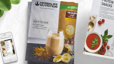 Catalogue produits Herbalife sur une table couverture du catalogue produits herbalife nutrition et page recettes d'en-cas proteines sur une table